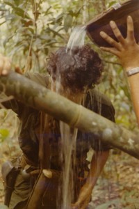 Medic gets water poured on head. Song Be, Vietnam 1970