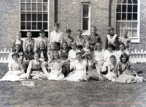 Grade 5 Class Portrait:Class picture of the Academy Hill School fifth grade, 1957. Back row, left to right: Peter Metters, Frank Powers, Barry Zlotin, Dick Larrabee, Nick Ferrantella, Dennis Brown, Leonard Ringler, David Hardy, Dan Connell. Middle row: Donna Glidden, Pam Lawrence, Sandy Pope, Melodie Watts, Karen Lamb, Haydi Craig, Cynthia Perkins, Susan Lusk, Joanna Simms, Susan Michetti. Front row: Mary Jean Nelson, Sheila Fulton, Louisa Dennis, Susan Chase, Susan Tucker, Jackie Mainhart, Marie Stackpole. Academy Hill School. Nantucket 1957